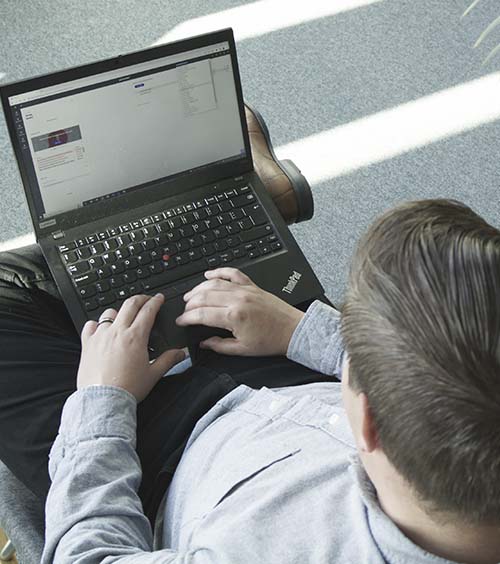 Mies lukee tietokoneelta nettovarallisuudesta.