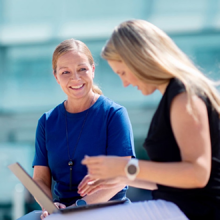 two women sitting outdoors