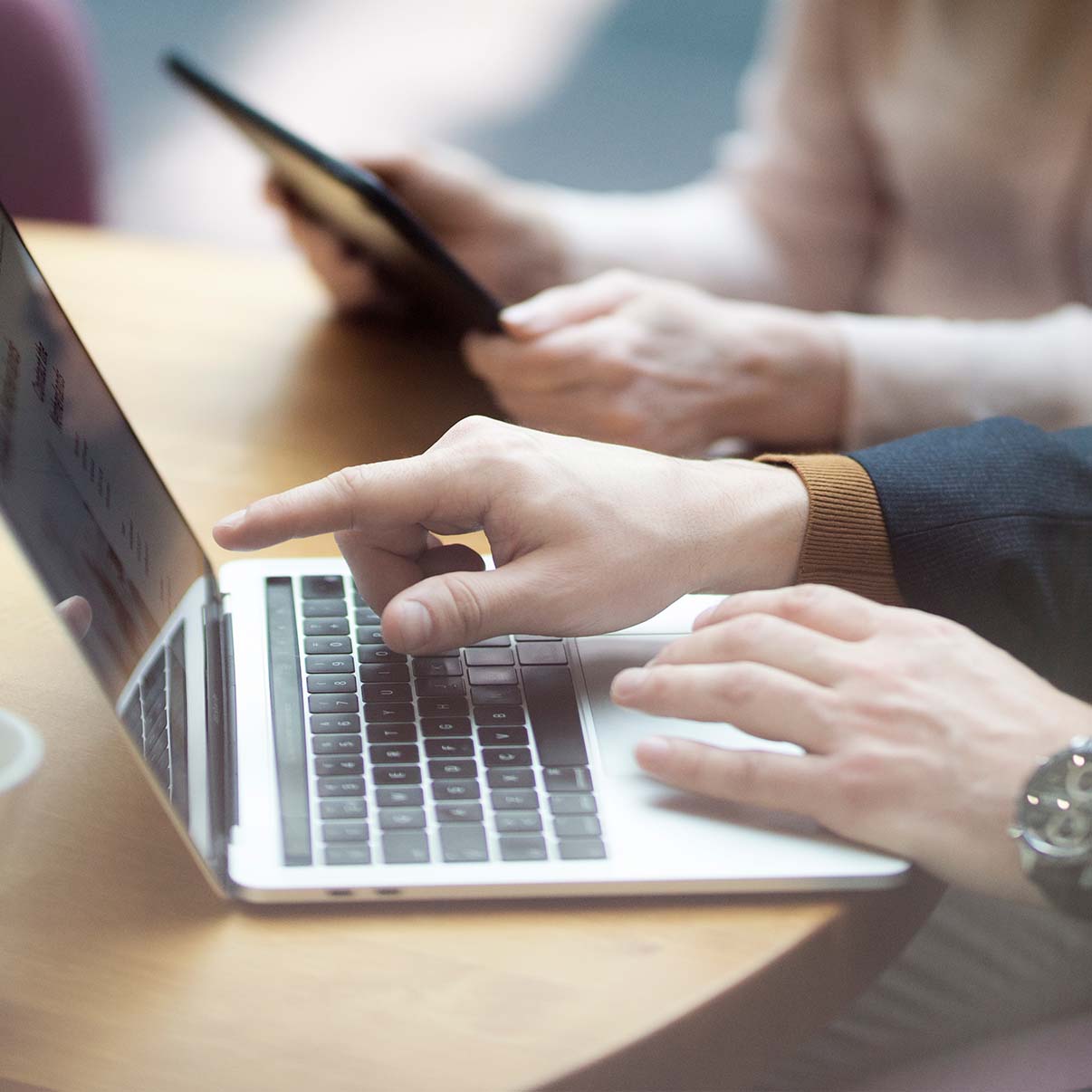 Miehen käsi osoittaa tietokoneelta palkka-avoimuuden muutoksia.