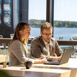 Nainen ja mies tutkivat asiakassopimusta tietokoneelta