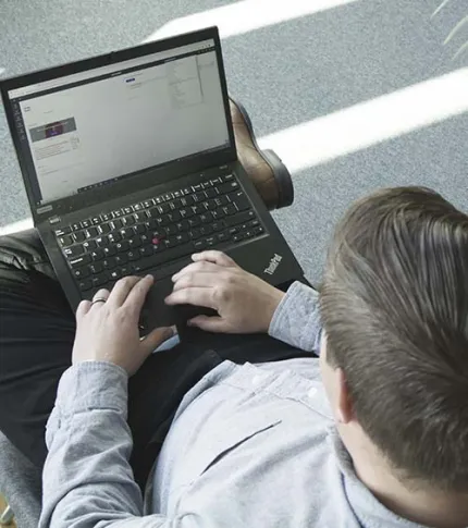 Mies lukee tietokoneelta nettovarallisuudesta.